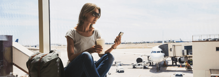 Woman In Airport On Phone Drinking Coffee Woman In Airport On Phone Drinking Coffee